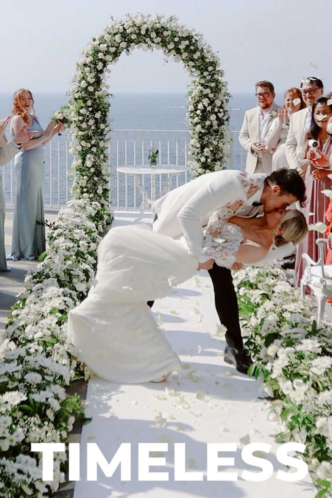 Bride and groom sharing a romantic dip kiss during their wedding ceremony at Villa Antiche Mura in Sorrento overlooking the Mediterranean Sea.