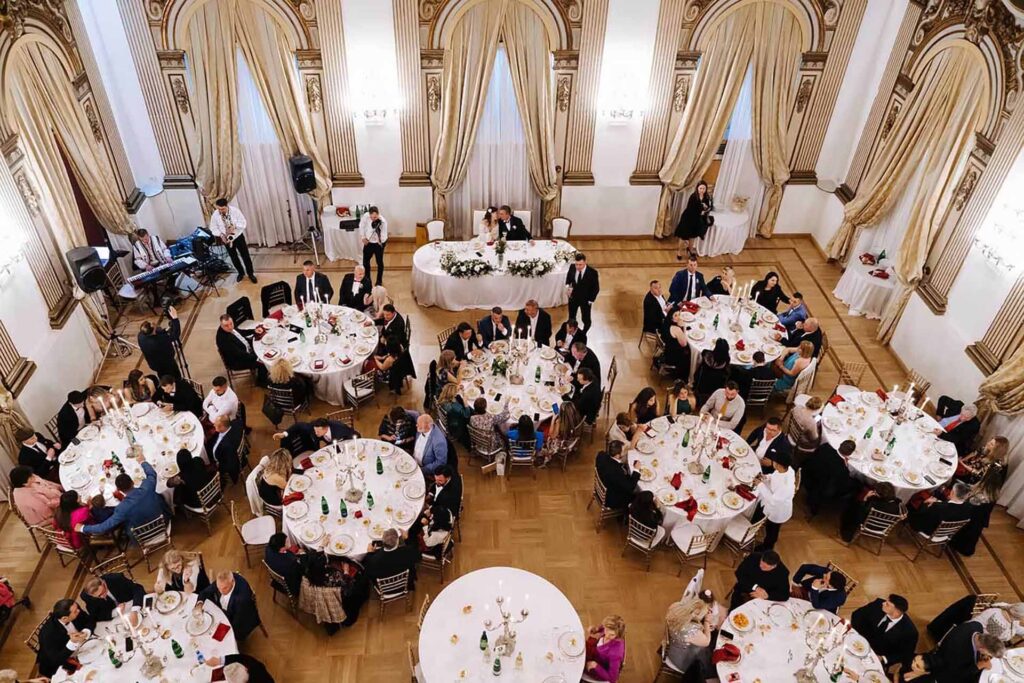 Wedding reception at Castello Brancaccio in Rome with elegant banquet hall and guests seated at round tables