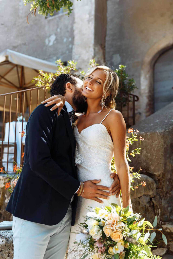 Romantic wedding couple portrait at Borgo di Tragliata near Rome, Italy, embracing in the sunlit countryside venue