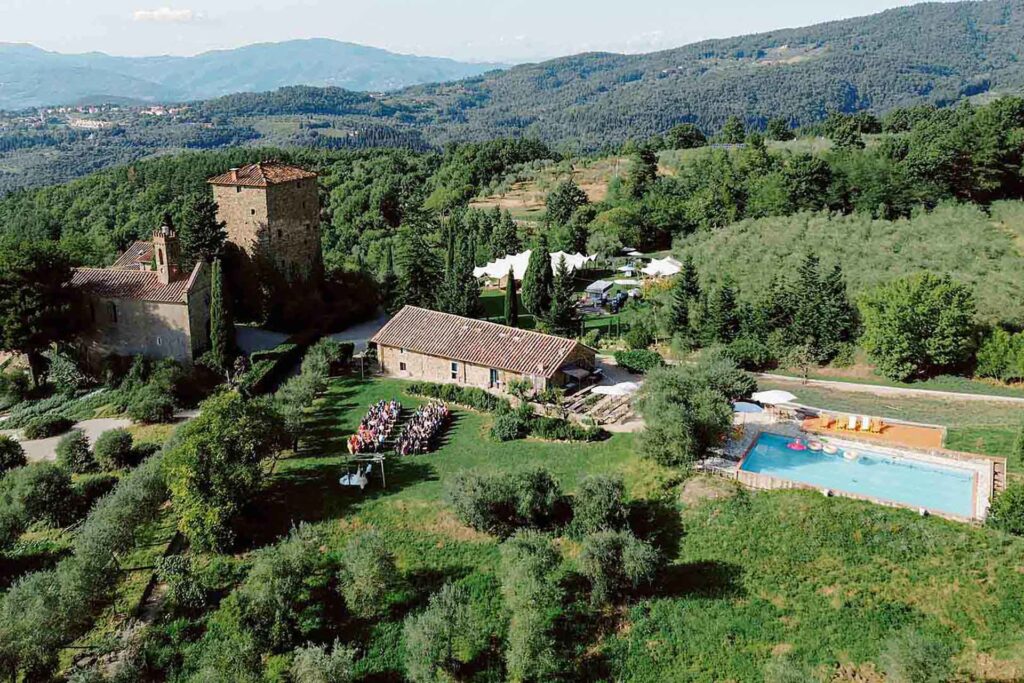 Aerial drone view of Castello di Ristonchi wedding ceremony in the Tuscan countryside with olive groves and swimming pool