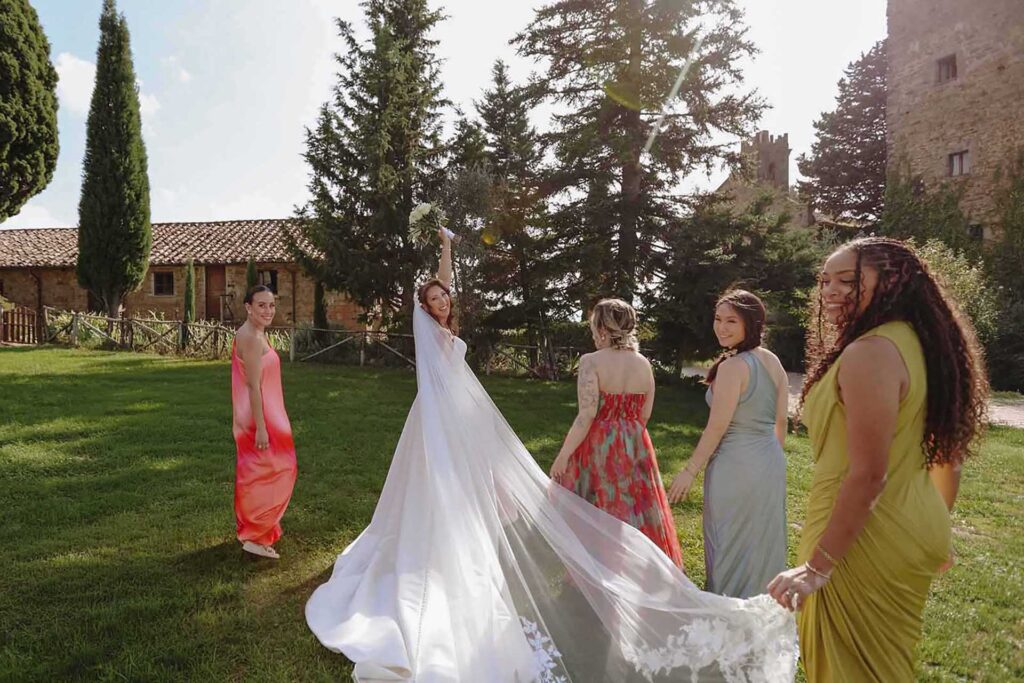 Bride walking with bridesmaids at Castello di Ristonchi in Tuscany during a destination wedding in Italy