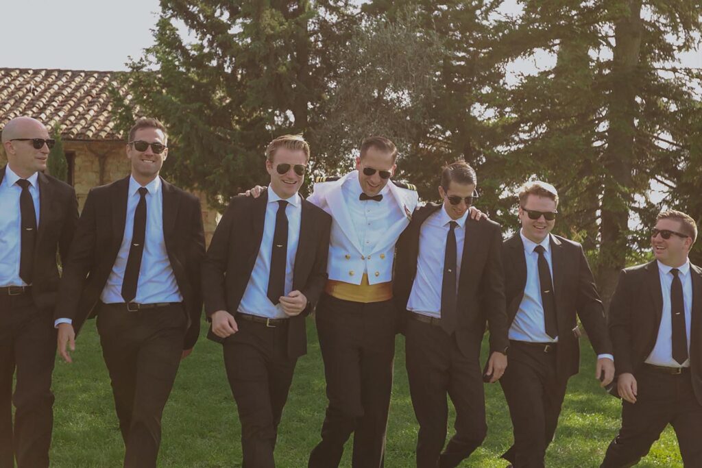 Groom and groomsmen walking together at Castello di Ristonchi in Tuscany during a luxury destination wedding