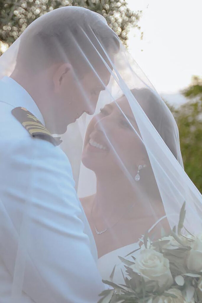 Bride and groom embracing under the veil during sunset wedding at Castello di Ristonchi in Tuscany, Italy