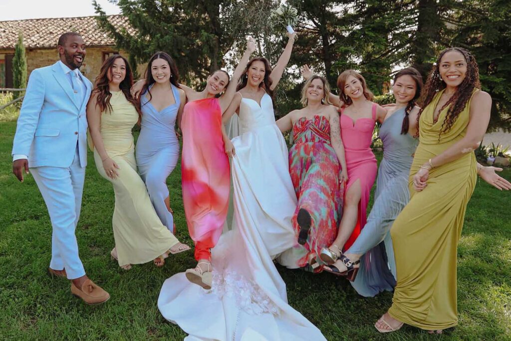 Wedding party enjoying lush green Tuscan countryside in May with soft light