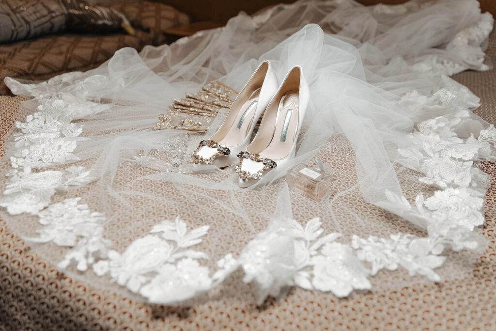 Luxury bridal shoes and lace veil detail photographed at La Grotte Resort in Valle di Comino, Italy