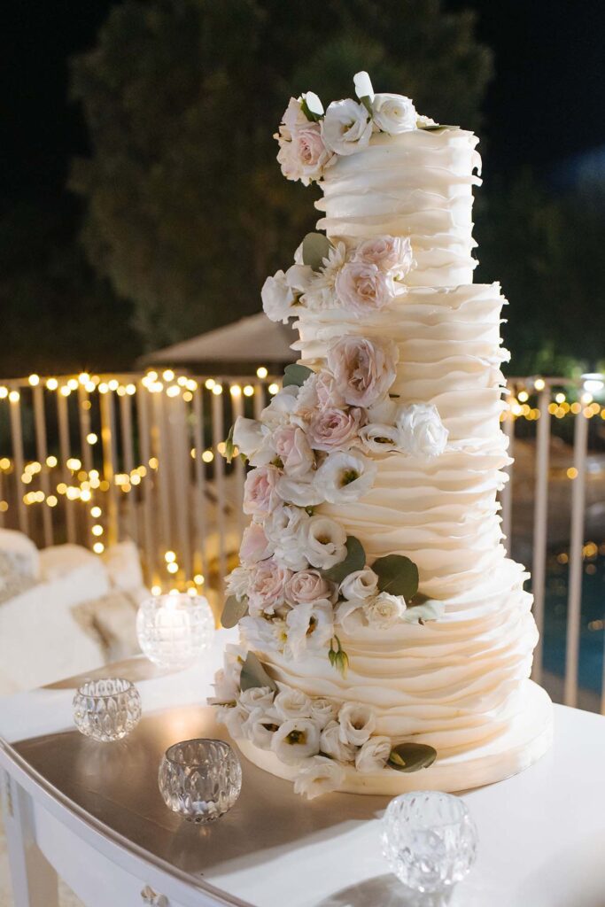 Elegant multi-tier wedding cake at La Grotte Resort in Valle di Comino decorated with white and blush flowers