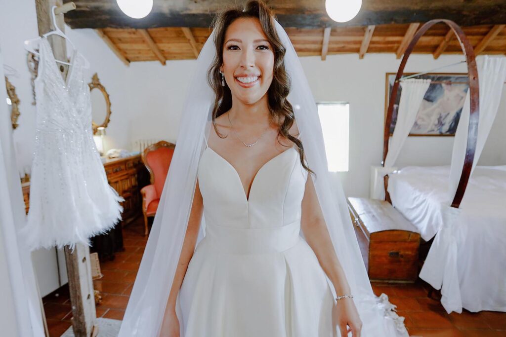 Bride Lauren smiling in natural light outdoors at a Tuscan villa, showing natural colour editing