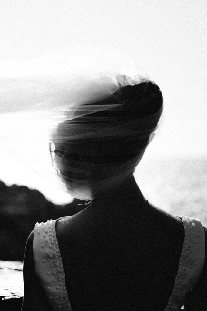 Black and white artistic portrait of a bride with flowing veil during a destination wedding in Portovenere, Italy