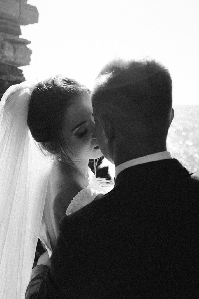 Black and white intimate wedding portrait of bride and groom embracing in Portovenere, Liguria overlooking the sea