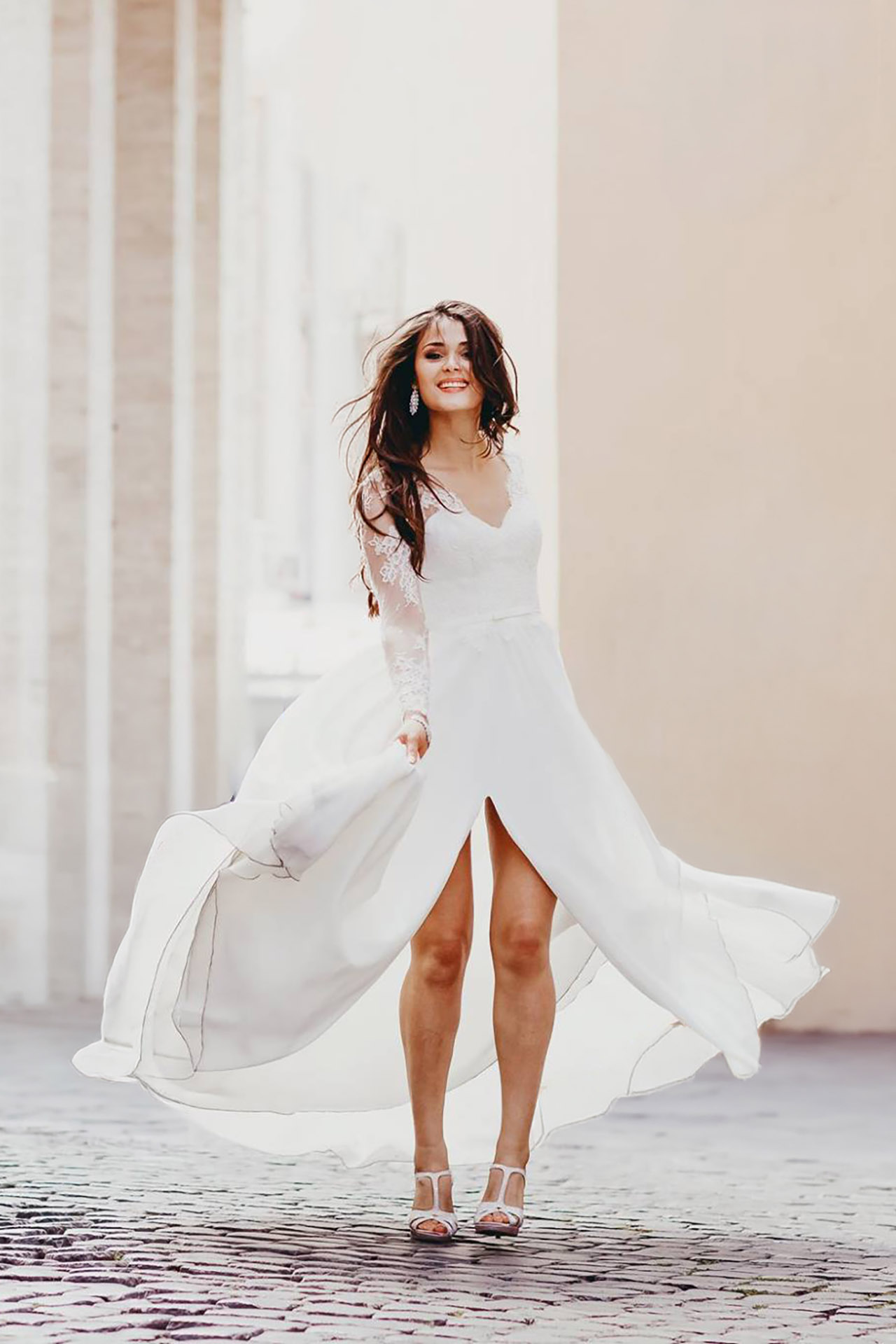 Sposa con abito da sposa fluido che cammina tra le strade storiche di Roma durante una sessione fotografica editoriale di ritratti bridal.