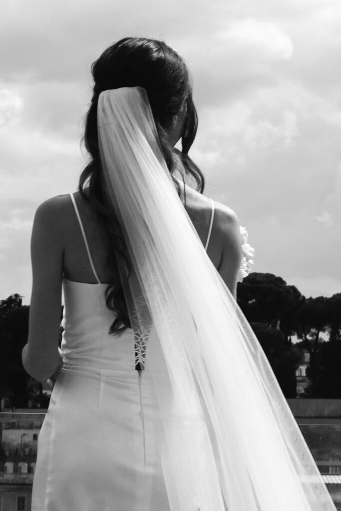 Black and white bridal portrait with veil at Terrazza Les Étoiles in Rome overlooking the city skyline