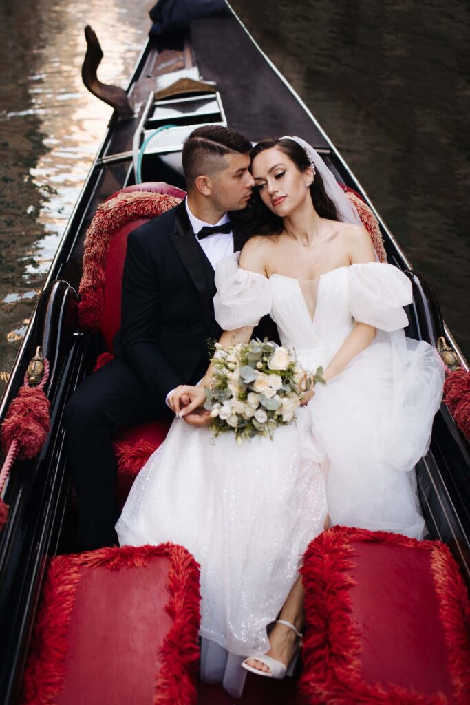 Bride and groom in a romantic gondola ride in Venice, Italy during a luxury destination wedding photoshoot