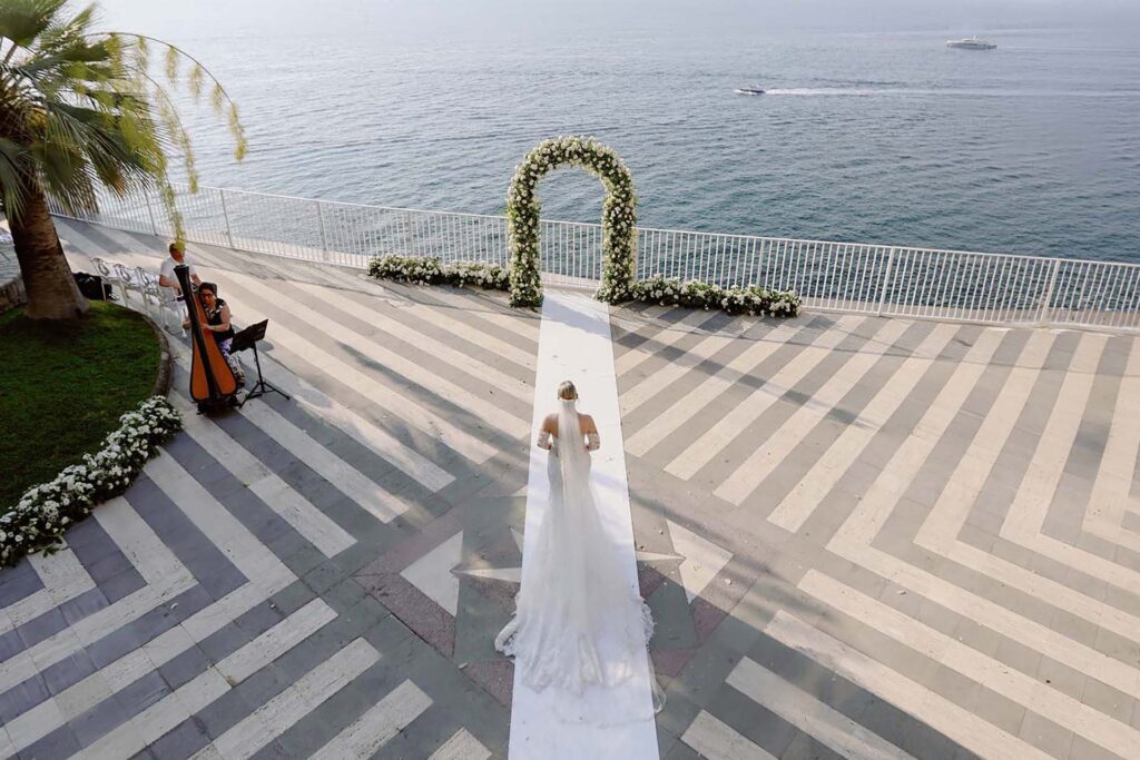 Bride walking down the aisle at Villa Antiche Mura in Sorrento overlooking the Mediterranean Sea during a luxury destination wedding ceremony