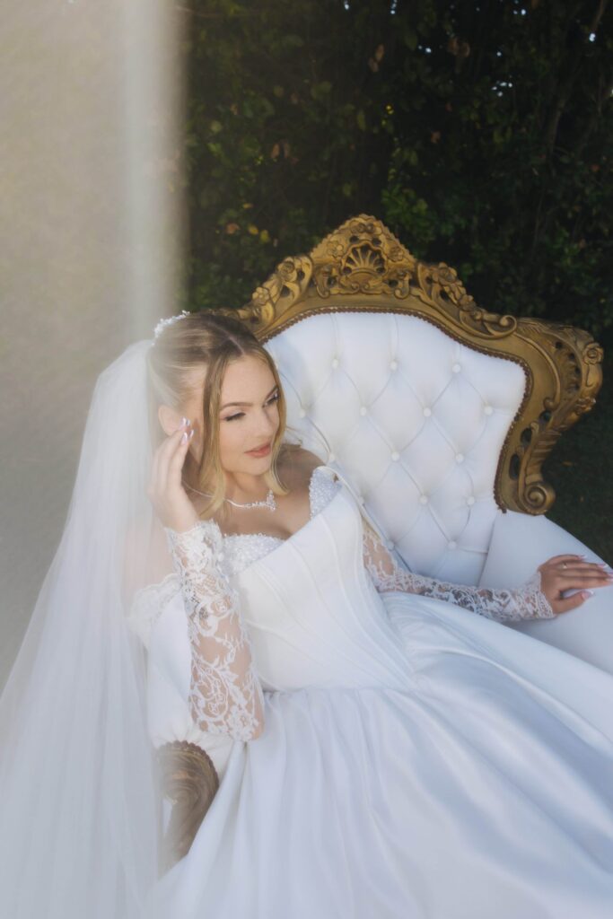 Bride seated on an ornate white and gold chair during a soft editorial portrait at a villa in Rome