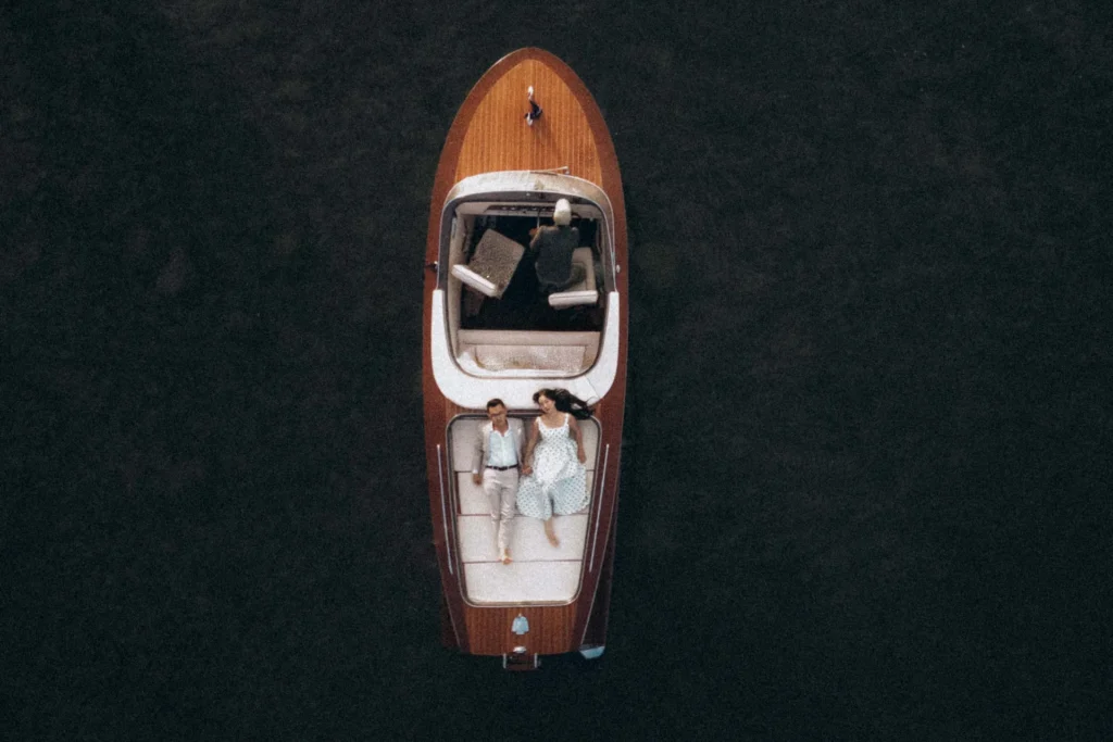 Overhead view of a wooden motorboat surrounded by dark water on Lake Como